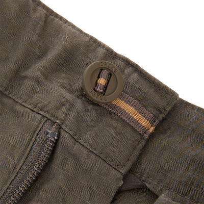 Close-up of 9 Pocket Ripstop Short's waistband, featuring a DRAKE buckle, zipper, and reinforced stitching; designed for adventure with self-adjusting fit and multiple pockets.