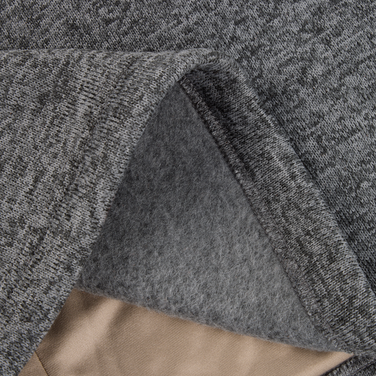 Close-up of the Fall Brake Sweater Fleece Vest by Sale, highlighting its grey heathered fabric, soft fuzzy inner lining, smooth outer surface, and a small edge of beige fabric underneath.