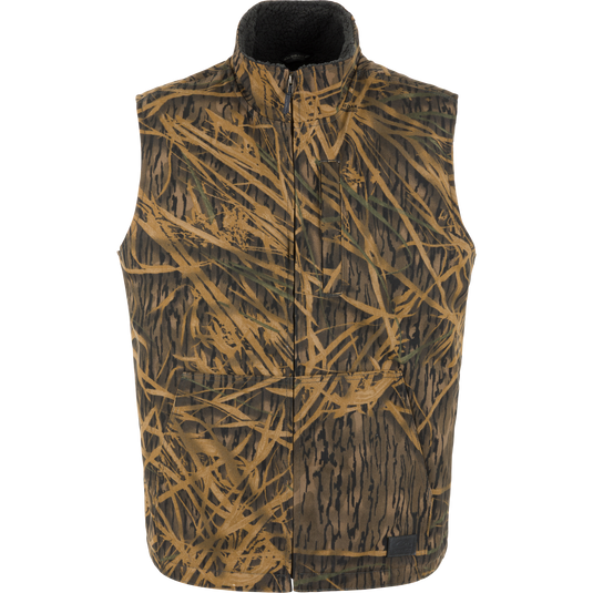 Lifestyle Canvas Sherpa Lined Work Vest in a brown and green camouflage grass pattern with a zippered front and a dark sherpa-lined interior.
