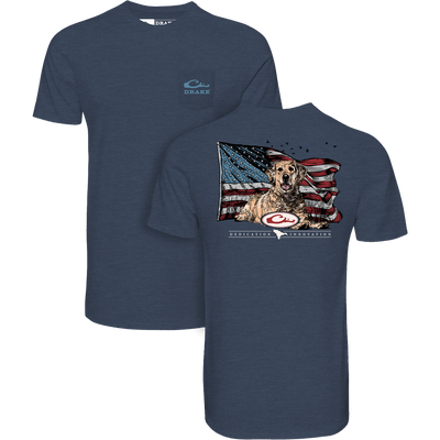 The Lifestyle Americana Yellow Lab Flag T-Shirt in Spellbound features a small Drake Waterfowl logo on the front and a bold yellow lab with an American flag and DEDICATION & INSPIRATION on the back.