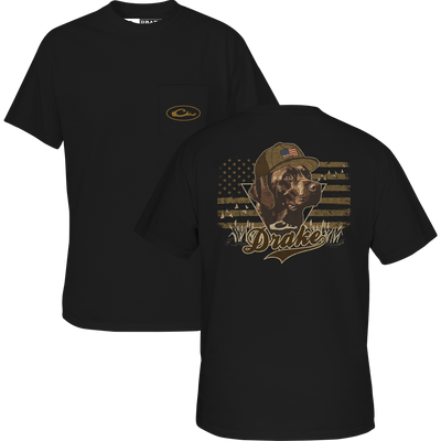 Lifestyle Blackout Lab Flag T-Shirt in black features a small front pocket logo and a back graphic of a black lab with an American flag and camo grass, plus “Drake” below. Part of the Americana Drake Series.