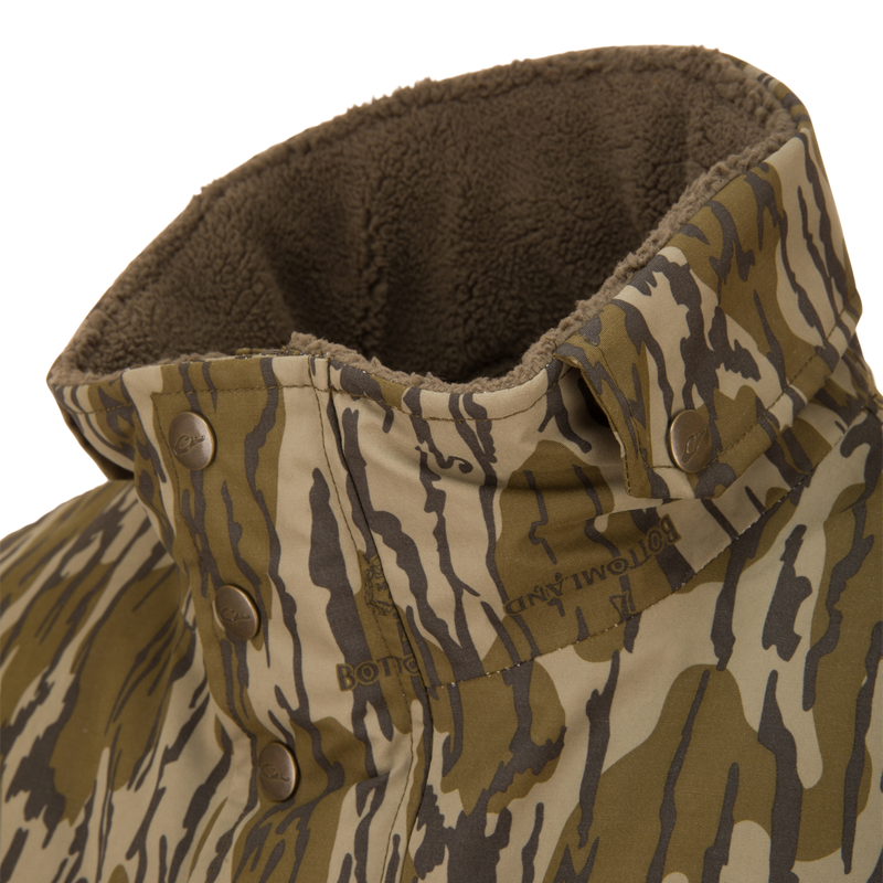 Close-up of the Throwback 80 Insulated Sport Bomber Jacket's collar showing tiger-stripe camo pattern, metal snap buttons, and visible brown sherpa lining.