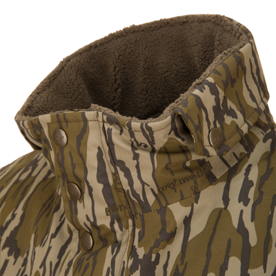 Close-up of the Throwback 80 Sport Vest collar, featuring tiger-stripe camo pattern, snap-button fasteners, and brown fleece lining for warmth and comfort.