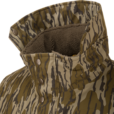 Close-up of the Throwback 80 Sport 3-in-1 Jacket's collar, showcasing tiger-stripe camo pattern, fleece lining, and metal snap buttons for outdoor versatility.