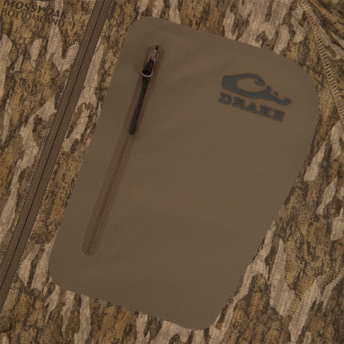 Close-up of Drake's EST Offset 1.0 Half Zip Pullover, highlighting zippered pocket, woodland camo pattern, and Drake logo, emphasizing comfort and functionality features.