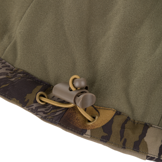 Olive green Drake X Ducks Unlimited LST BMF Jacket with Primaloft hem featuring a brown plastic drawstring toggle and elastic cord.