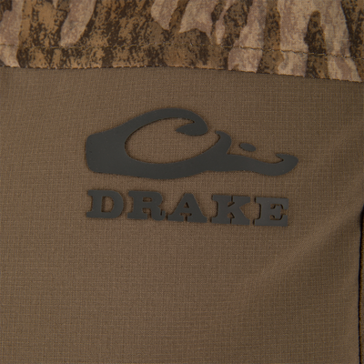 Close-up of the LST BMF Vest with Primaloft, featuring the Drake Waterfowl logo on camouflage fabric, showcasing its windproof, water-resistant materials, and practical Magnattach™ pocket.