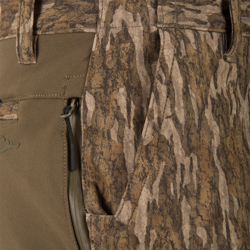 Close-up of MST CommandXT Softshell Pant showing camo print, zippered pocket, and belt loop, highlighting its durable, flexible design for demanding outdoor activities.