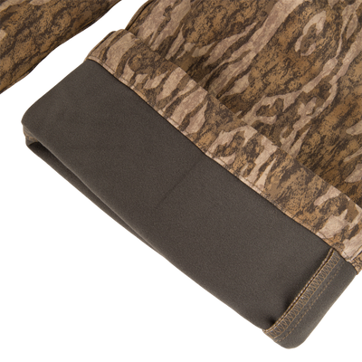 Close-up of the MST Youth CommandXT Softshell Pant leg cuff, featuring a dark brown panel at the hem and a brown camouflage pattern.