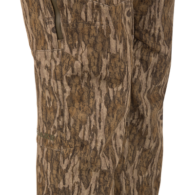Close-up of MST Youth CommandXT Softshell Pant camouflage hunting pants, featuring windproof, water-resistant fabric, zippered side pockets, and a stretch waistband.