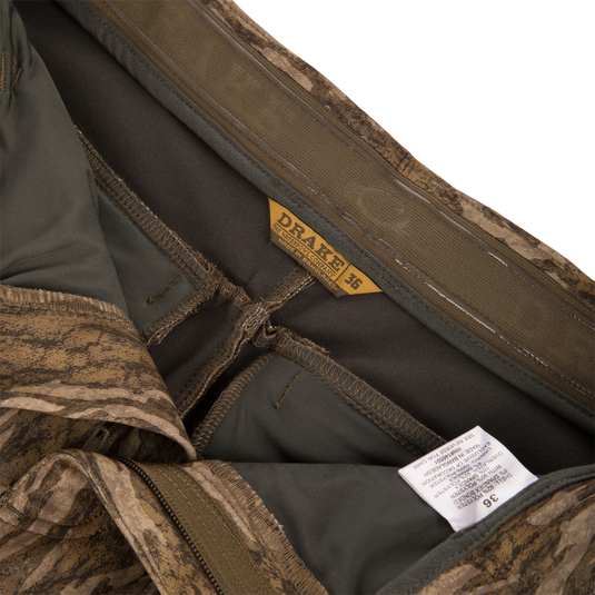 Interior view of MST Youth CommandXT Softshell Pant camouflage pants showing the stretch waistband, branded tag, and care label.