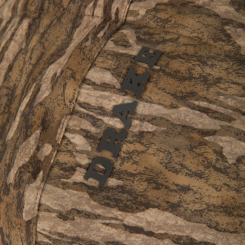 Close-up of LST BMF Eqwader Half Zip Jacket with Primaloft featuring a DRAW. seam detail, showcasing its woodland camouflage pattern and durable construction.