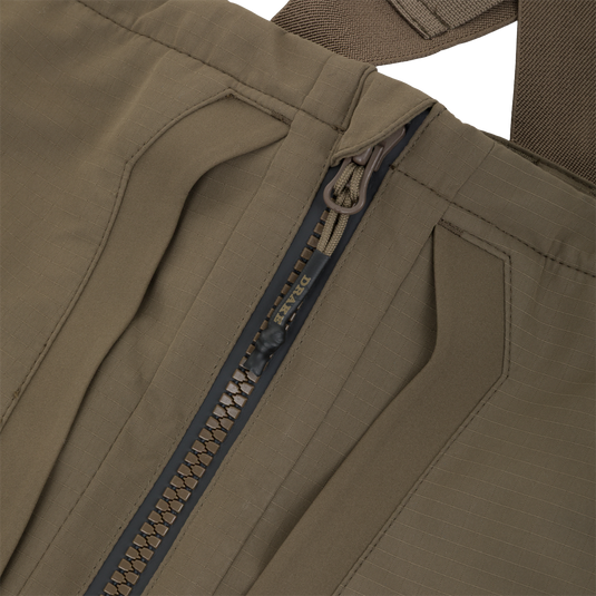 Close-up of the front zipper on olive green Drake X Ducks Unlimited LST BMF Pit Bib with Primaloft waterfowl hunting bibs.