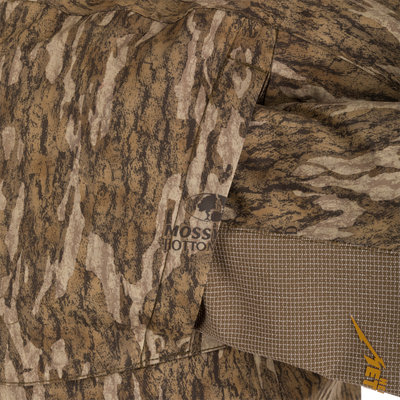 Close-up of the LST BMF 3-in-1 Pit Jacket with Primaloft, showcasing Mossy Oak Bottomland camo pattern, stitched pocket, and YETI logo.