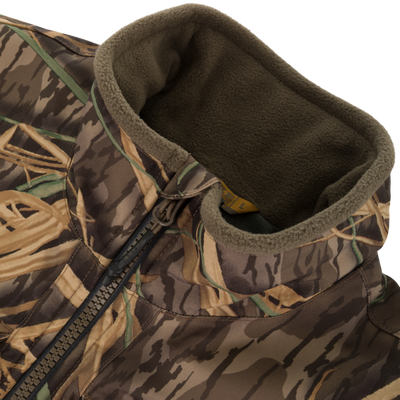 Close-up of the Waterfowl CommandXT Eqwader Vest, featuring a camouflage pattern, abrasion-resistant build, zippered front, and soft olive-green fleece-lined collar.