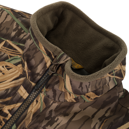 Close-up of the Waterfowl CommandXT Eqwader Vest, featuring a camouflage pattern, abrasion-resistant build, zippered front, and soft olive-green fleece-lined collar.