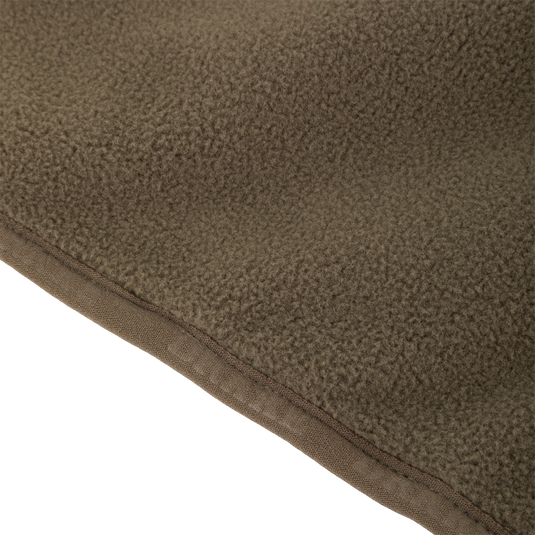 Close-up of Waterfowl CommandXT Eqwader Vest fabric, showcasing its soft, textured brown fleece and stitched edge.