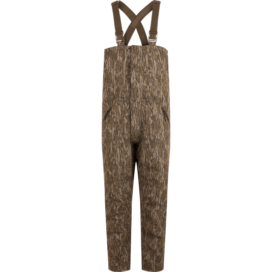 LST Hardline Insulated Bib designed for wooded hunting, features durable waterproof fabric, synthetic insulation, and functional zippers for easy wear in harsh environments.