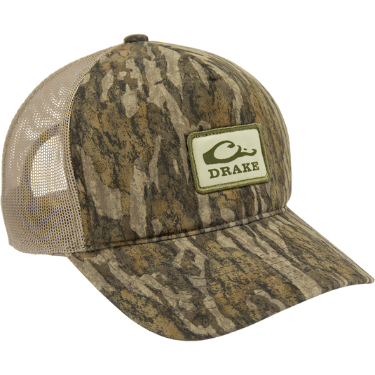 Drake's Foam Trucker Logo Cap features a woodland camo front with a mesh back, pre-curved visor, and the iconic Drake logo patch.