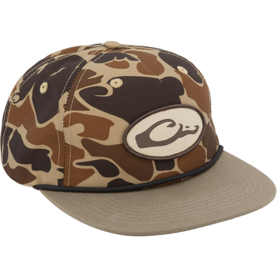 The Drake X Lost Hat Hybrid Goat Rope Cap by Waterfowl features an Old School camo pattern, a tan brim, 100% cotton fabric, a C-logo patch on the front, and a snap-back closure.