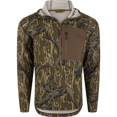 The Waterfowl EST Performance Half-Zip Hoodie in Mossy Oak Original Treestand offers a camo half-zip design with a front chest zip pocket, tan accents, and UPF30 protection—ideal for outdoor use.