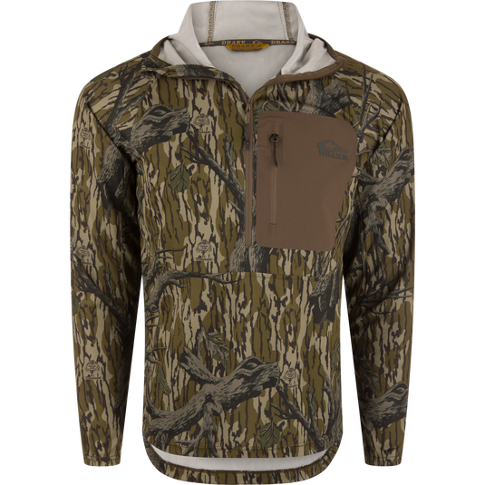 The Waterfowl EST Performance Half-Zip Hoodie in Mossy Oak Original Treestand offers a camo half-zip design with a front chest zip pocket, tan accents, and UPF30 protection—ideal for outdoor use.
