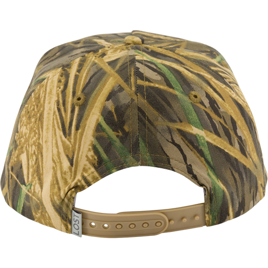 The Drake x Lost Hat BMF Goat Rope Cap by Waterfowl in camouflage features green, brown, and tan shades, an adjustable snapback strap, and a small white tag on the left side.