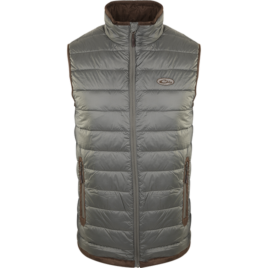 A silver-colored durable Synthetic Double Down Vest by Drake Waterfowl, featuring a horizontal baffle design, suede accents, and reverse coil zippers for outdoor warmth and style.