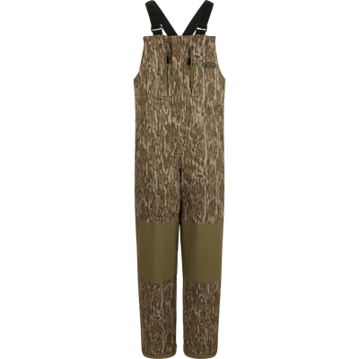 LST Reflex Insulated Bib with camouflage print, reinforced olive-green knees, zippered chest pockets, and adjustable suspenders, ideal for hunting and outdoor durability.
