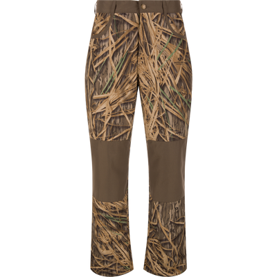 Front view of the Waterfowl MST Jean Cut Wader Pant in a brown and tan grass pattern with water resistance, reinforced knees, belt loops, and a button waist closure.