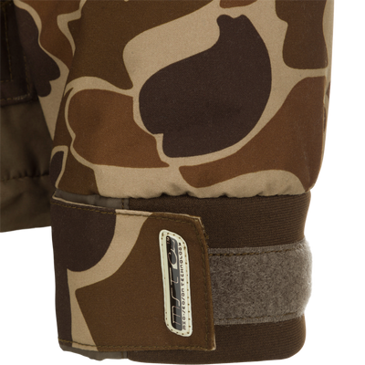 Close-up of MST Waterproof Fleece-Lined Quarter Zip Jacket's camo-print cuff with Velcro strap for wrist adjustment, featuring a branded tag on the tab.