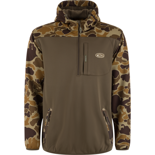 The Waterfowl MST Endurance Soft Shell Hoodie features a brown body with camouflage sleeves, hood, and shoulders, fleece-lined hood, half-zip front, chest logo patch pocket, and zippered hand pockets—perfect for the outdoors.