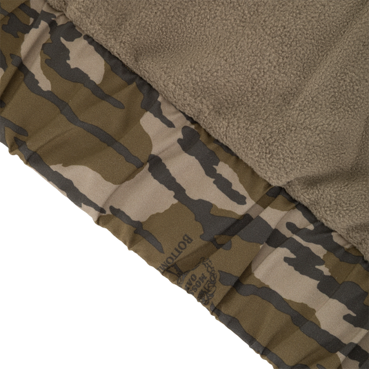Close-up of the interior of an MST Waterproof Full Zip Jacket w/ Hood, showing a soft brown fleece lining next to a patterned waterproof shell.