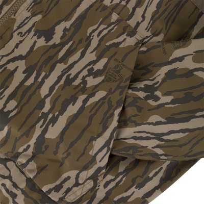 Close-up of a Sale MST Waterproof Full Zip Jacket w/ Hood featuring a zippered, windproof design in a brown and tan camouflage pattern with printed brand logos.