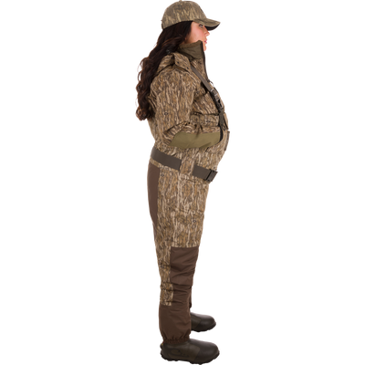 Woman wearing Women’s Insulated Guardian Elite Vanguard Breathable Waders with camouflage pattern, showcasing reinforced seams, cargo pouch, and insulated Thinsulate Buckshot Mud boots.