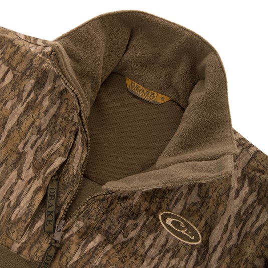 MST Youth Eqwader Quarter Zip Jacket featuring camo-patterned shell, fleece lining, embroidered chest logo, and patented waterproof/breathable technology for optimal comfort in waterfowl hunting.