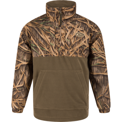 The MST Youth Eqwader Quarter Zip Jacket by Waterfowl features a Mossy Oak Original Shadow Grass camo upper, solid olive lower half, front zip, high collar, and a kangaroo pocket—perfect for waterfowl adventures.