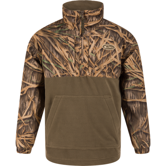 The MST Youth Eqwader Quarter Zip Jacket by Waterfowl features a Mossy Oak Original Shadow Grass camo upper, solid olive lower half, front zip, high collar, and a kangaroo pocket—perfect for waterfowl adventures.