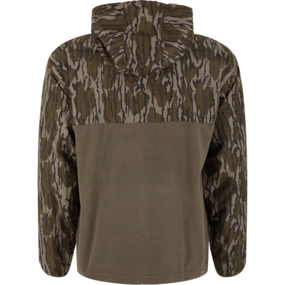 The MST Quarter Zip Refuge Eqwader Jacket with Hood by Waterfowl features brown and green camo on the upper, sleeves, and hood, plus a solid olive green lower back for breathable comfort in the field.
