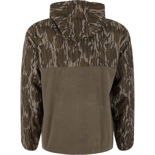 The MST Quarter Zip Refuge Eqwader Jacket with Hood by Waterfowl features brown and green camo on the upper, sleeves, and hood, plus a solid olive green lower back for breathable comfort in the field.