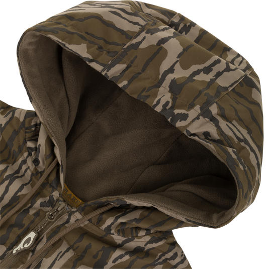A close-up of the MST Quarter Zip Refuge Eqwader Jacket with Hood by Waterfowl, showing its green and brown camo pattern, quarter zip, and soft dark hood lining.