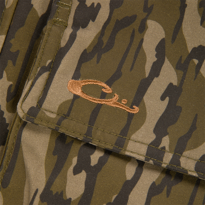 Close-up of a pocket flap on the MST Drake Dry Waxed Cotton Wading Jacket featuring an embroidered brown duck head logo.