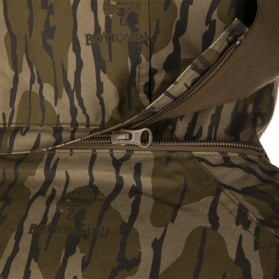 Close-up of a camouflage MST Drake Dry Waxed Cotton Wading Jacket with an open zipper and internal placket.
