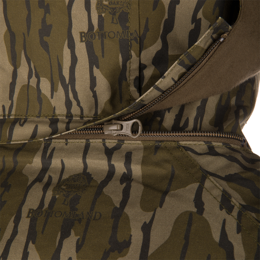 Close-up of a camouflage MST Drake Dry Waxed Cotton Wading Jacket with an open zipper and internal placket.
