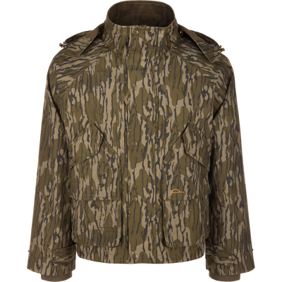 Waterfowl MST Drake Dry Waxed Cotton Wading Jacket in a Mossy Oak Original Bottomland tree bark camouflage pattern, featuring a high collar and front pockets for durable outdoor use.