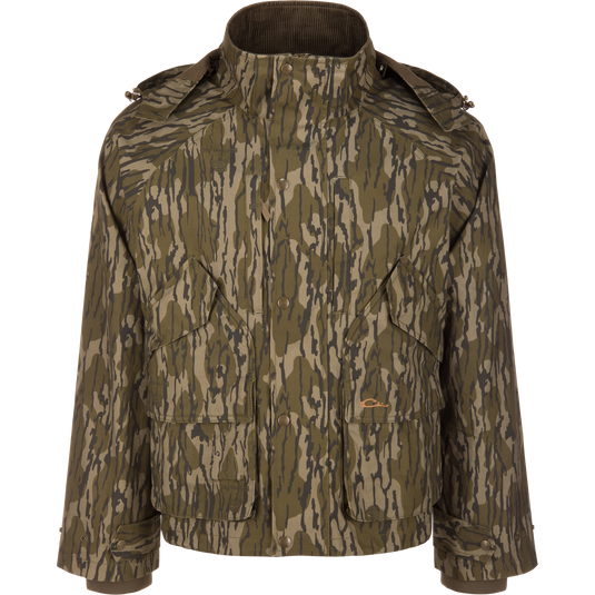 Waterfowl MST Drake Dry Waxed Cotton Wading Jacket in a Mossy Oak Original Bottomland tree bark camouflage pattern, featuring a high collar and front pockets for durable outdoor use.