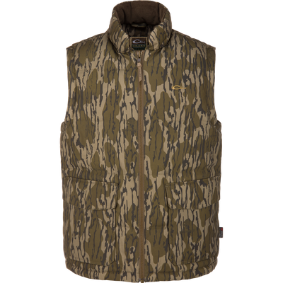 The Waterfowl LST Insulated Waxed Cotton Vest in Mossy Oak Original Bottomland features Thinsulate insulation, a zip-up front, and two large pockets, shown sleeveless against a white background.