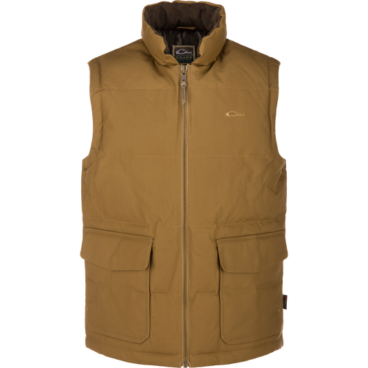 The LST Insulated Waxed Cotton Vest by Waterfowl in tan features a high collar, sleeveless design, front zipper, two large flap pockets, and a small chest logo, shown on a white background.