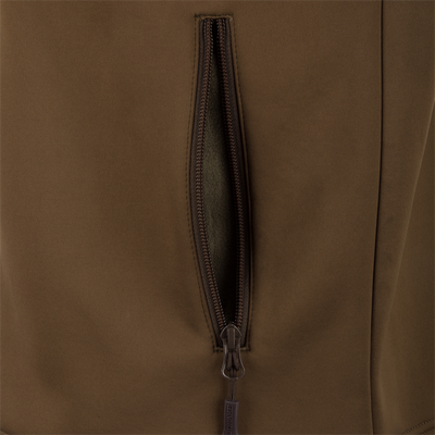A close-up of the Waterfowl MST Hole Shot Two-Tone Eqwader Vest in brown, featuring a windproof design and a partially open vertical zippered pocket revealing the interior.