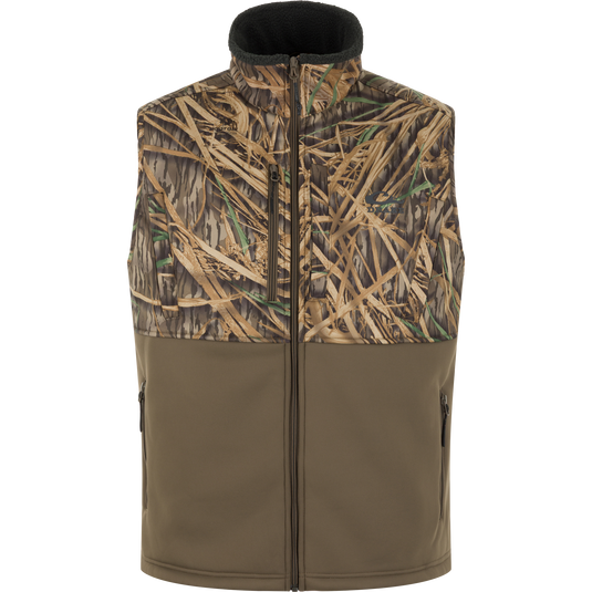 The MST Hole Shot Two-Tone Eqwader Vest by Waterfowl in Mossy Oak Original Shadow Grass Two-Tone features a sleeveless, windproof design with a zip front and two-tone camo and olive panels, shown against a white background.
